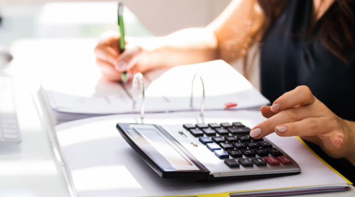 Business woman completes tax paperwork and calculates finance on calculator