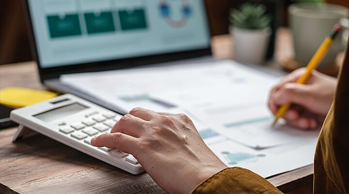 Person is calculating depreciation on their tax return for their laptop sitting in the background